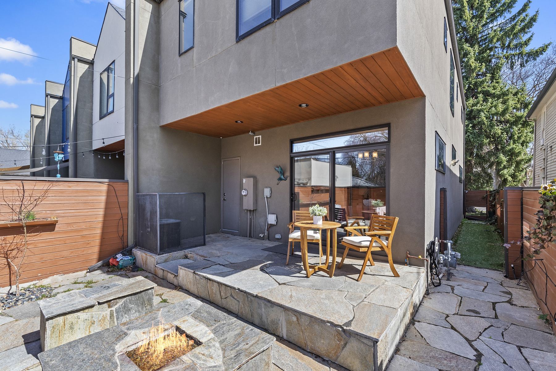 Built-in stone gas fire pit with bench seating in a private Boise courtyard